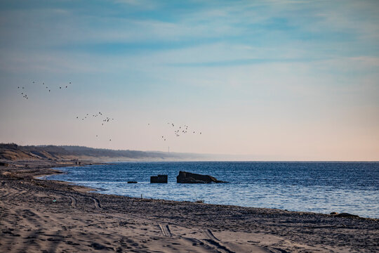 A deserted sandy beach on the shores of a calm blue sea, the Baltic Spit