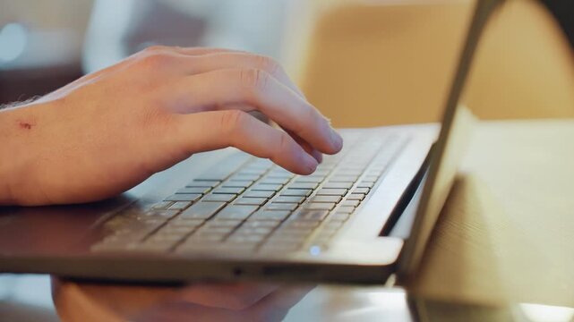 Closeup of white hands coding on compact laptop, terminal visible on screen, latenight workspace vibe, warm desk light, focused rhythm, wrist scar, ambient bokeh, iterative debugging flow