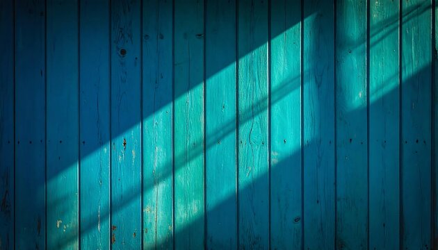Close-up of vertical, turquoise-painted wooden planks with a beam of sunlight casting a shadow across them. Texture and depth are evident