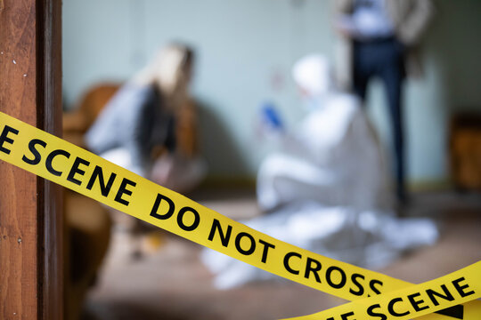 Yellow crime scene tape marking off an area while investigators analyze evidence, focusing on law enforcement and mystery themes