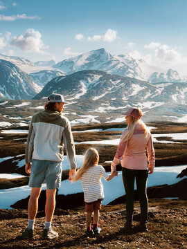Family travel parents and child on hiking vacations outdoor together in Norway - father, mother and daughter holding hands enjoy mountains view in Lahko national park, healthy lifestyle active people