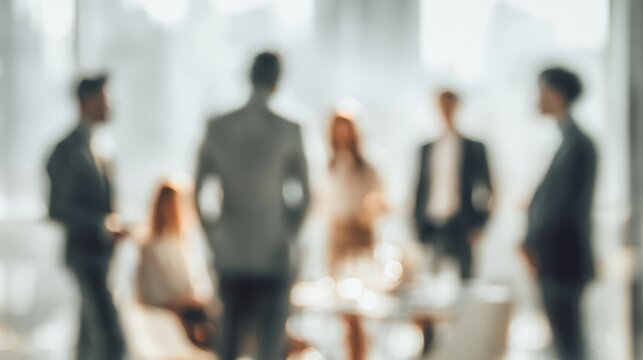 Blurred Business Discourse: A professional gathering, seen through a soft focus lens, where ideas flow freely and collaborations take shape within an office environment. 