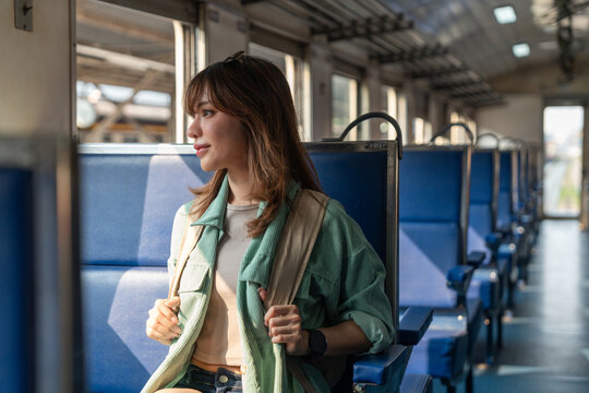 Freedom traveler beautiful woman at terminal train station. Happy tourist travel by train on vacation time holiday weekend trip. Female Backpacker arrival at platform railway.