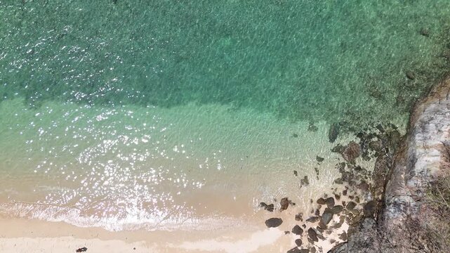 Aerial View of Serene Beach with Turquoise Water and Rocky Shoreline Creating Peaceful Coastal Scene with Gentle Waves