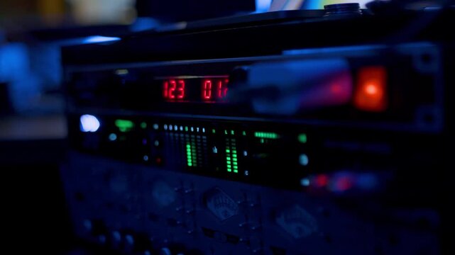 Equipo de audio profesional con indicadores LED y medidores VU en estudio de grabaci&oacute;n - 4K