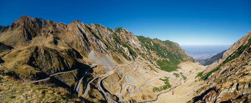 Epic mountain panoramic view of Transfagarasan Highway winding through vast Fagaras Mountains in Romania.