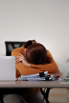 Tired sleepy woman fell asleep while sitting at the table at home