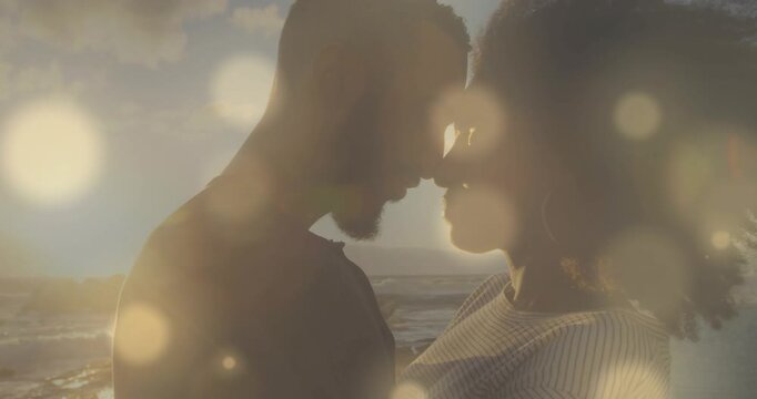 Couple closing as man leaning forward heads touching on shore bokeh framing seeking closeness film