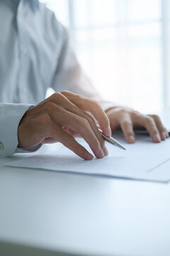 Businessman reviewing company documents and financial reports at office desk