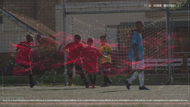 Youth soccer ball from right, attackers shooting, keeper blocking holding ball, red streak overlay