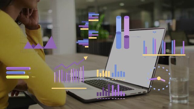 Woman sitting at table monitoring laptop while business feed triggers waveform and bars over laptop