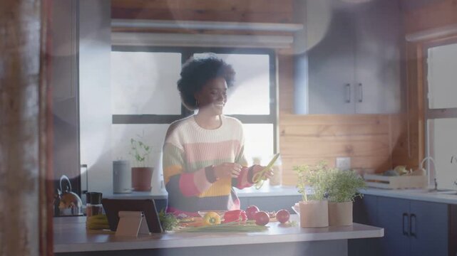 Food home cook referencing tablet, picking tomatoes and scallions, tending herb, following recipe