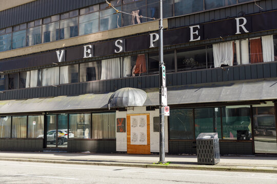 The boarded-up Vesper Hotel SRO building facade with For Lease sign and broken windows on a downtown Vancouver street on a sunny spring day.