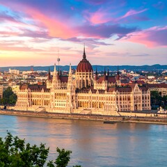 Obraz premium Ornate, multi-domed building along a wide river, viewed at sunset. City skyline and colorful sky in the background