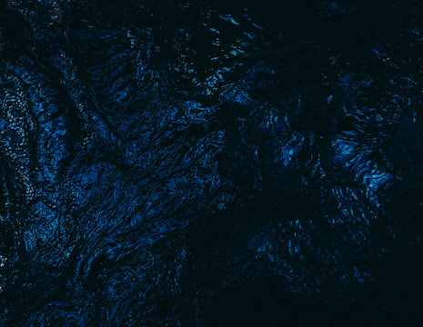 Deep blue water current with dark ripples and liquid movement