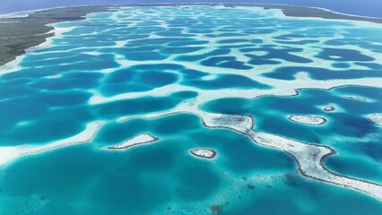 Fototapeta premium Aerial drone shot of turquoise lagoon in French Polynesia with tropical island, clear blue water and luxury travel destination