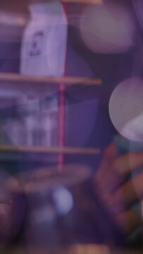 Vertical video: Drummer noticing loose mount, adjusting cymbal stand in studio, aligning amid bokeh
