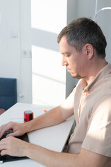 Obraz premium A man works at his desk at home, in a home office, writing, signing, and stamping his name