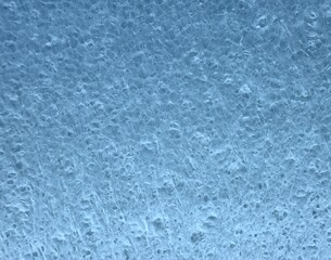Fototapeta premium Macro shot of blue porous foam or sponge texture showing small holes and uneven surface, ideal as an abstract background representing material structure, cleaning concept, or industrial design