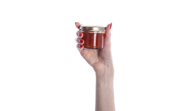 Glass jar of red caviar in hand isolated on white background.