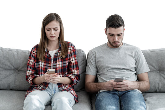 Girl and guy sitting on sofa looking at their phones avoiding communication with each other