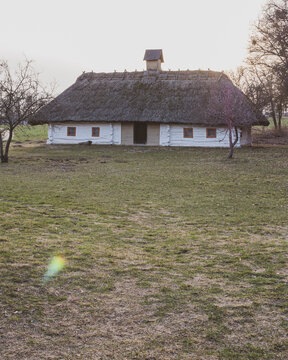 Historic Ukrainian farmhouse with straw roof and small framed windows 
