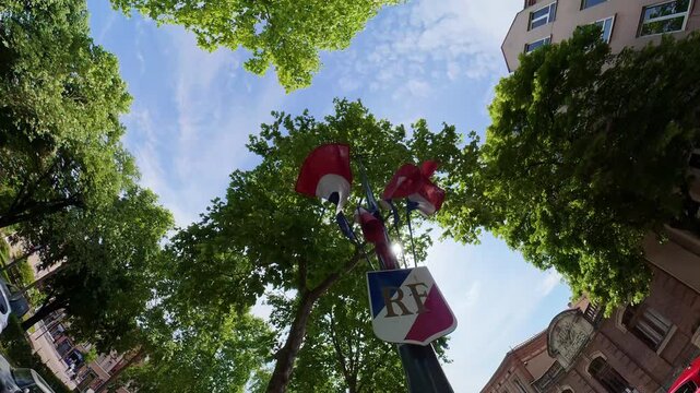 street lamp tricolor blue white red flags RF shield under plane trees blue sky Albi