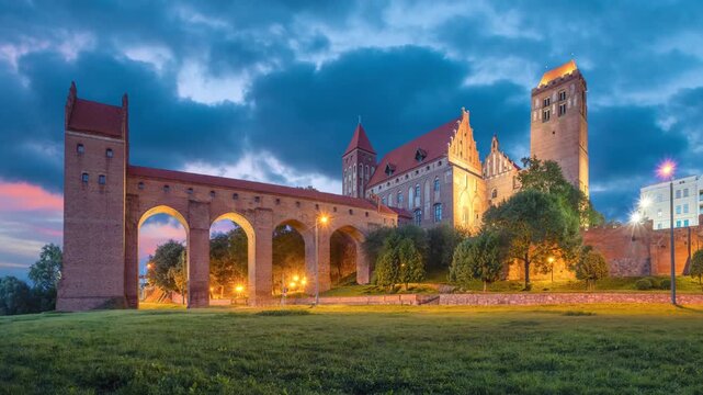 View of illuminated Kwidzyn Castle at dusk with a dansker tower, Poland (static image with animated sky)