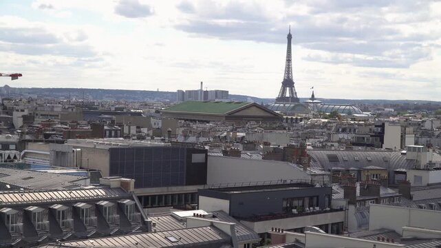 Wide panorama of Paris rooftops with Eiffel Tower in the distance
