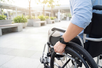 Fototapeta premium Disabled young man confidently gripping wheelchair wheel outdoors