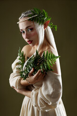 Obraz premium Beautiful elf girl with floral decor on dark olive background