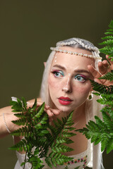 Obraz premium Beautiful elf girl with floral decor on dark olive background