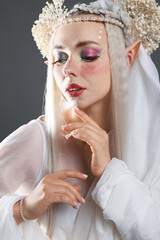 Obraz premium Beautiful girl dressed as elf on grey background