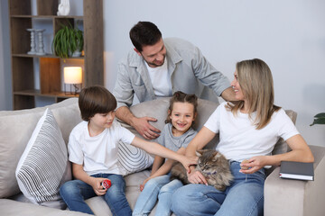 Obraz premium Happy family with their cute cat at home. Adorable pet