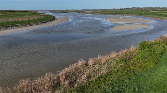 Survol de la Sienne, rivi&egrave;re entre Regn&eacute;ville-sur-Mer et Heugueville-sur-Sienne, peu avant sa rencontre avec la Manche. Traveling vertical ascendant.