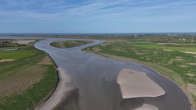 Survol de la Sienne, rivi&egrave;re entre Regn&eacute;ville-sur-Mer et Heugueville-sur-Sienne, peu avant sa rencontre avec la Manche. Traveling vertical descendant.