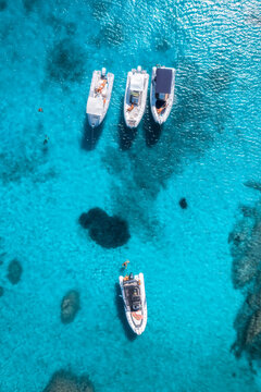 Aerial drone view of beautiful luxury yachts and boats in blue sea in summer. Sardinia, Italy. Top down view of speed boats, turquoise water. Tropical landscape. Yachting. Seascape. Summer vibe