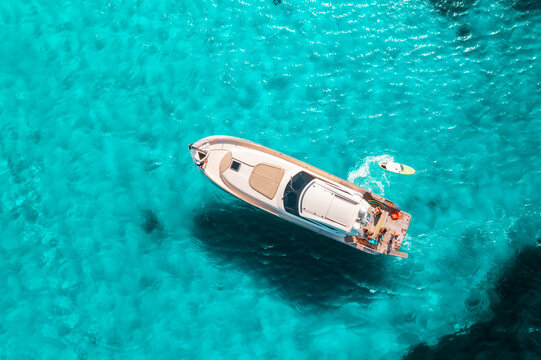 Aerial drone view of beautiful luxury yacht in blue sea in summer. Sardinia island, Italy. Top down view of boat, sea bay with turquoise water. Tropical holiday. Yachting. Summer vacation and travel