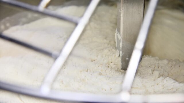 Mixing dough with a stand mixer, flour gradually blending with ingredients