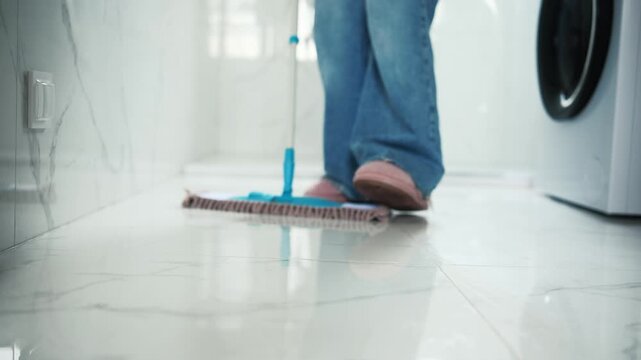 Close-Up Of A Woman Cleaning The Bathroom Floor