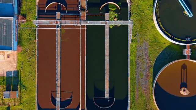Symmetrical aerial view of industrial water purification tanks. Geometric top down perspective of wastewater treatment facility showing different stages of water cleaning.