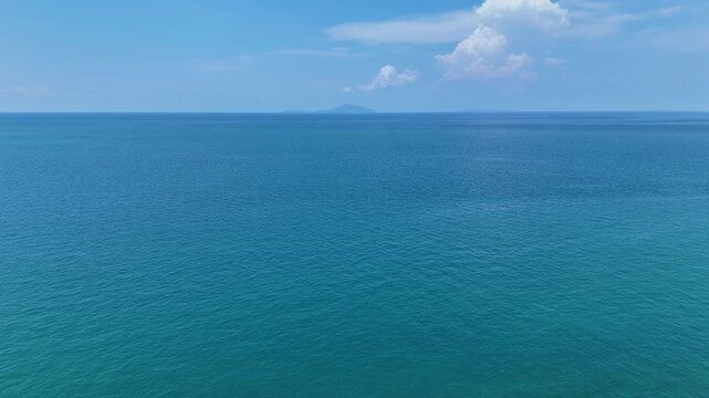 Vast Blue Ocean and Calm Sea Under Clear Sky with Distant Clouds Creating Serene and Tranquil Horizon Atmosphere