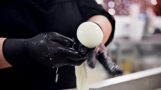 Preparing burrata cheese with stracciatella, hands forming and shaping cheese