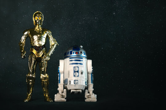 C3PO and R2D2 action figures characters from the Star Wars movie saga and space for text. Illustrative editorial