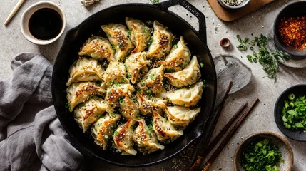 Chinese traditional lunar new year Spring Festival celebration in Asia. A topdown view of a cast iron skillet filled with steamed dumplings, sesame seeds, and green onions. © rabbit75_fot