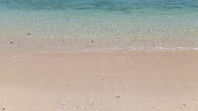 Serene Beach Scene Gentle Waves Lapping at Sandy Shoreline, Showcasing Clear Blue Ocean Water and Tranquil Atmosphere