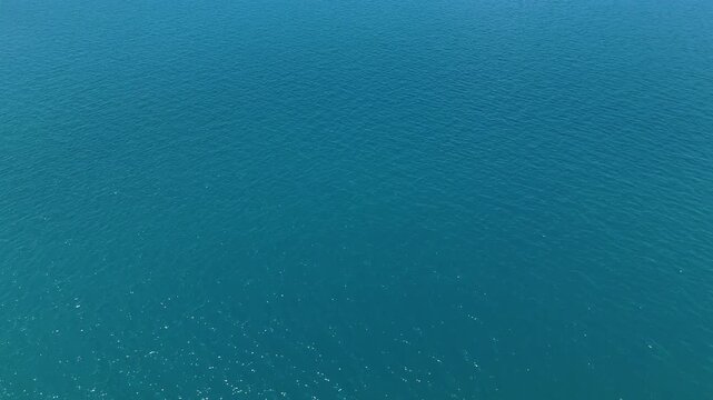 Aerial View of Serene and Peaceful Blue Ocean Calm Sea with Gentle Ripples and Waves Creating Tranquil Water Atmosphere