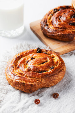 Raisin swirl Danish pastry with scattered raisins and milk