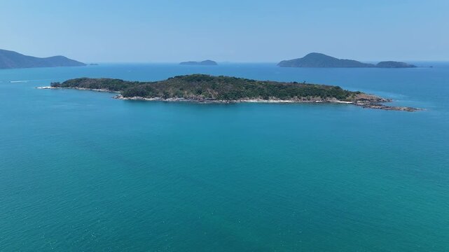 Serene Aerial View of Lush Green Island Surrounded by Clear Blue Sea Under Bright Sky, Evoking Tranquility and Nature Escape