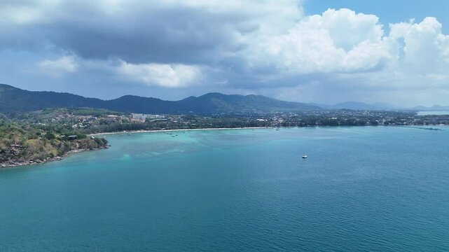 Serene Aerial View of Turquoise Waters and Lush Green Hills Coastal Landscape Under Partly Cloudy Sky